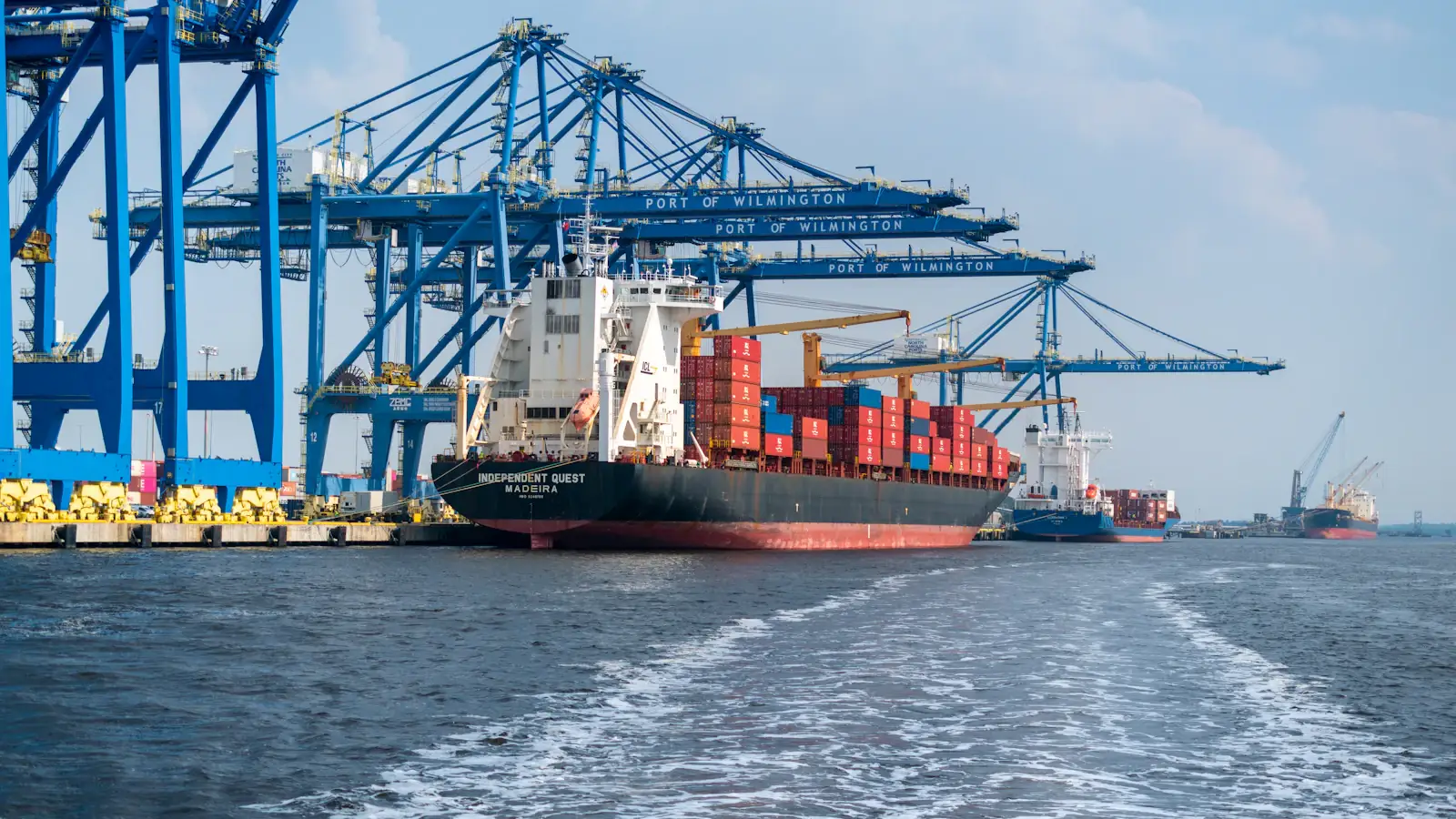Large cargo ship beside a port crane, the trade flows settled in stablecoins between businesses