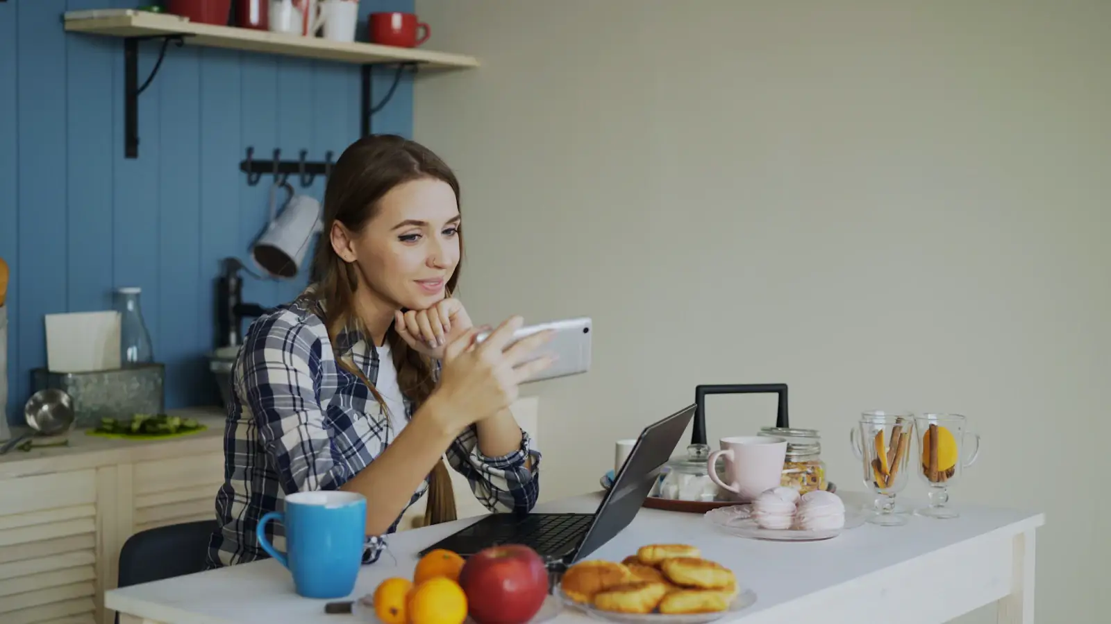 Smiling woman on a video call from her kitchen, staying connected with family abroad
