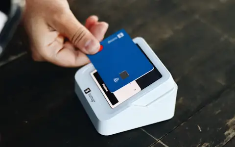 Person holding a payment card in hand, ready for a business expense