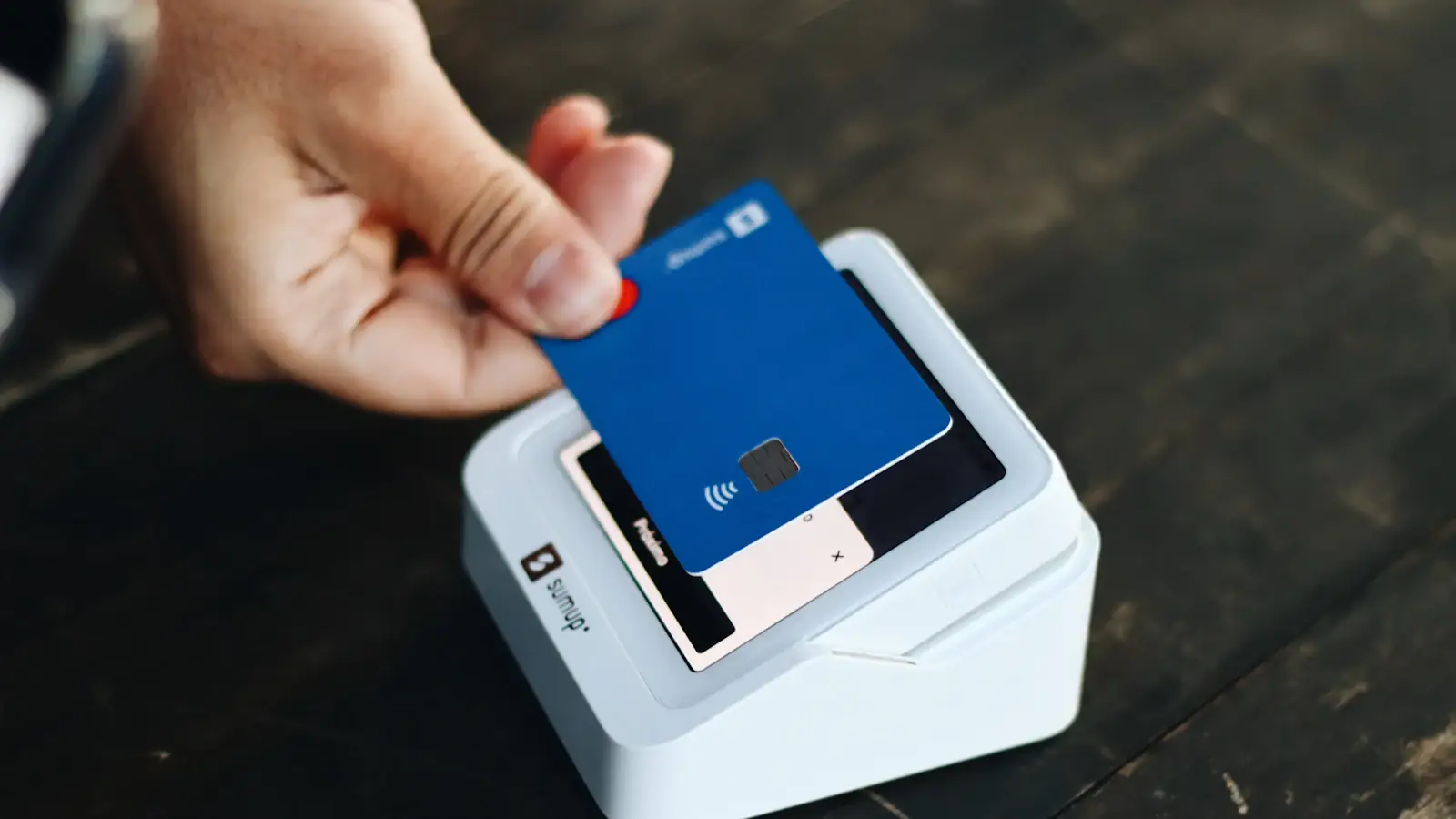 Person holding a payment card in hand, ready for a business expense