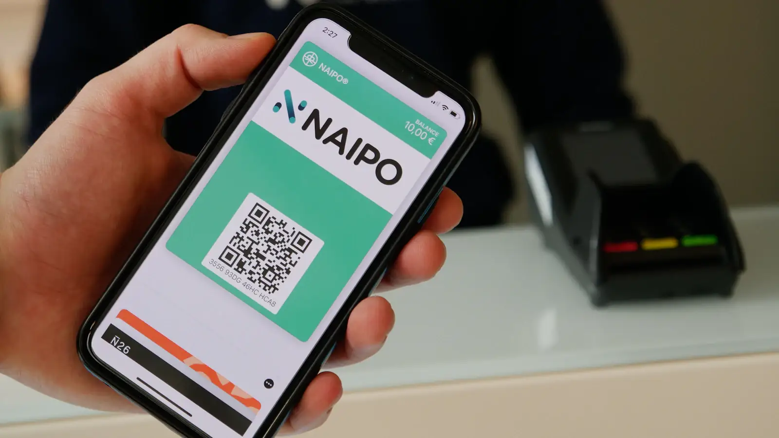 Person holding a smartphone in warm light, using a digital payment app