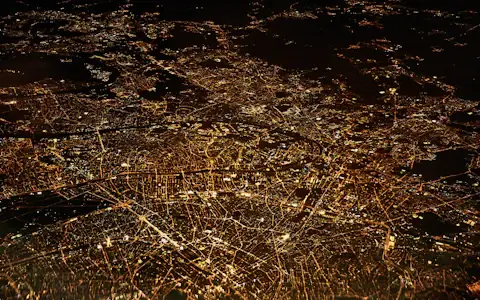 Aerial night view of glowing city light networks, evoking global payment rails like Ripple