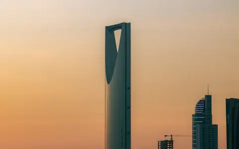 Kingdom Centre skyscraper against a warm orange sky in Riyadh, Saudi Arabia's fintech capital