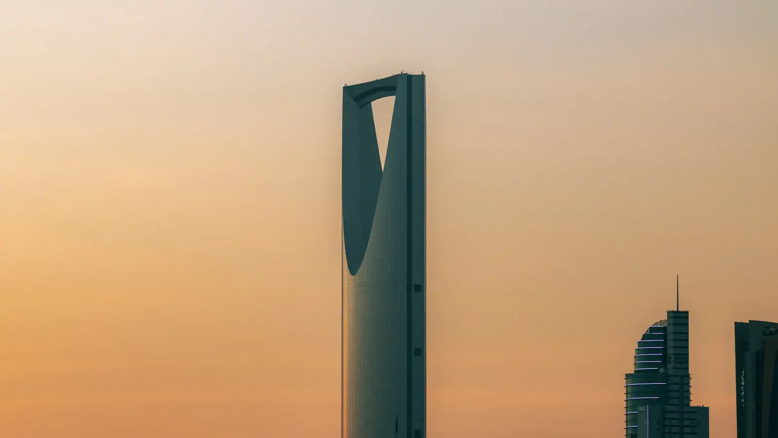 Kingdom Centre skyscraper against a warm orange sky in Riyadh, Saudi Arabia's fintech capital