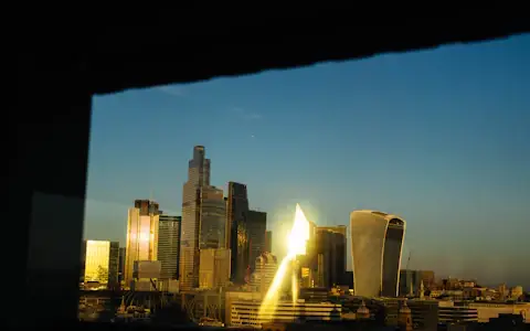Modern skyscrapers glowing at sunset, financial skyline representing stablecoin issuers and payment rails