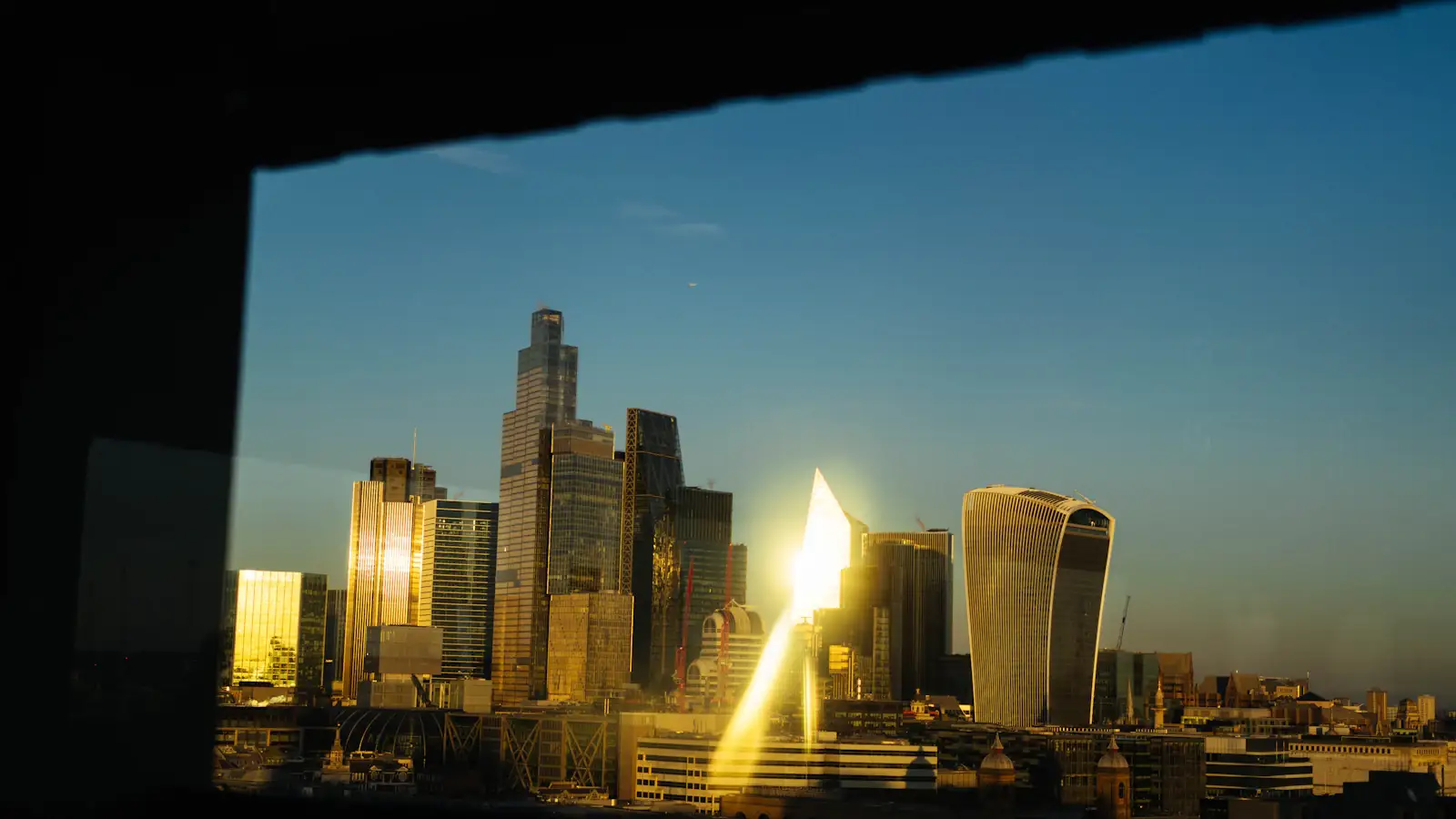 Modern skyscrapers glowing at sunset, financial skyline representing stablecoin issuers and payment rails