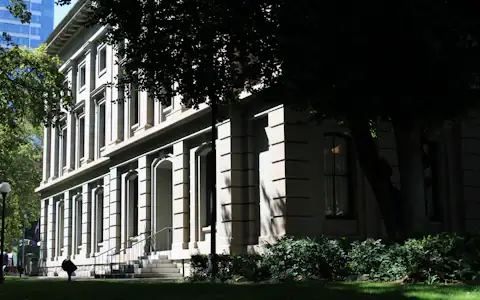 Historic sandstone courthouse framed by green trees, symbolising stablecoin law and regulation