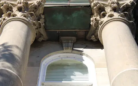 Tall stone bank building with classical columns seen from street level