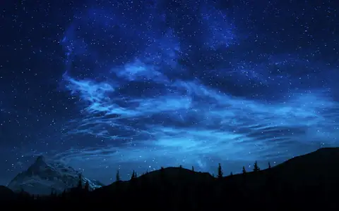 Night sky full of stars above a silhouetted line of trees