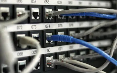 Blue network cables connected in a server rack, the messaging infrastructure behind SWIFT payments