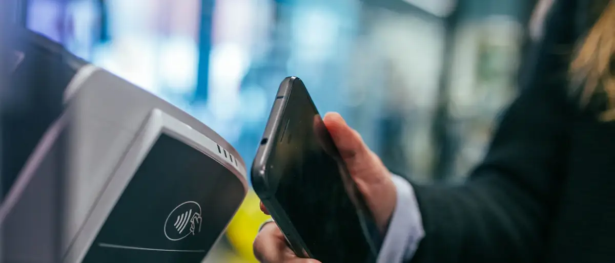 Woman using a smartphone at a payment terminal, a view of where payments are heading