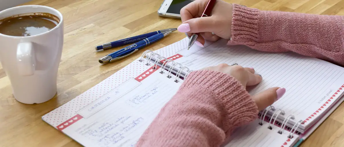 Person writing in a notebook beside a cup of coffee, planning money moves step by step