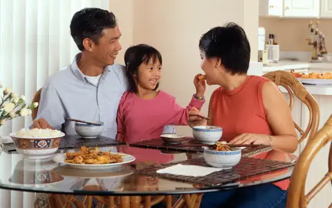 Asian family sharing a meal at home, the everyday costs remittances help cover