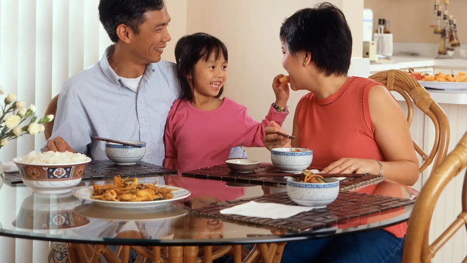 Asian family sharing a meal at home, the everyday costs remittances help cover