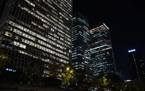 Bank office towers glowing at night, where wholesale CBDCs would settle payments between banks